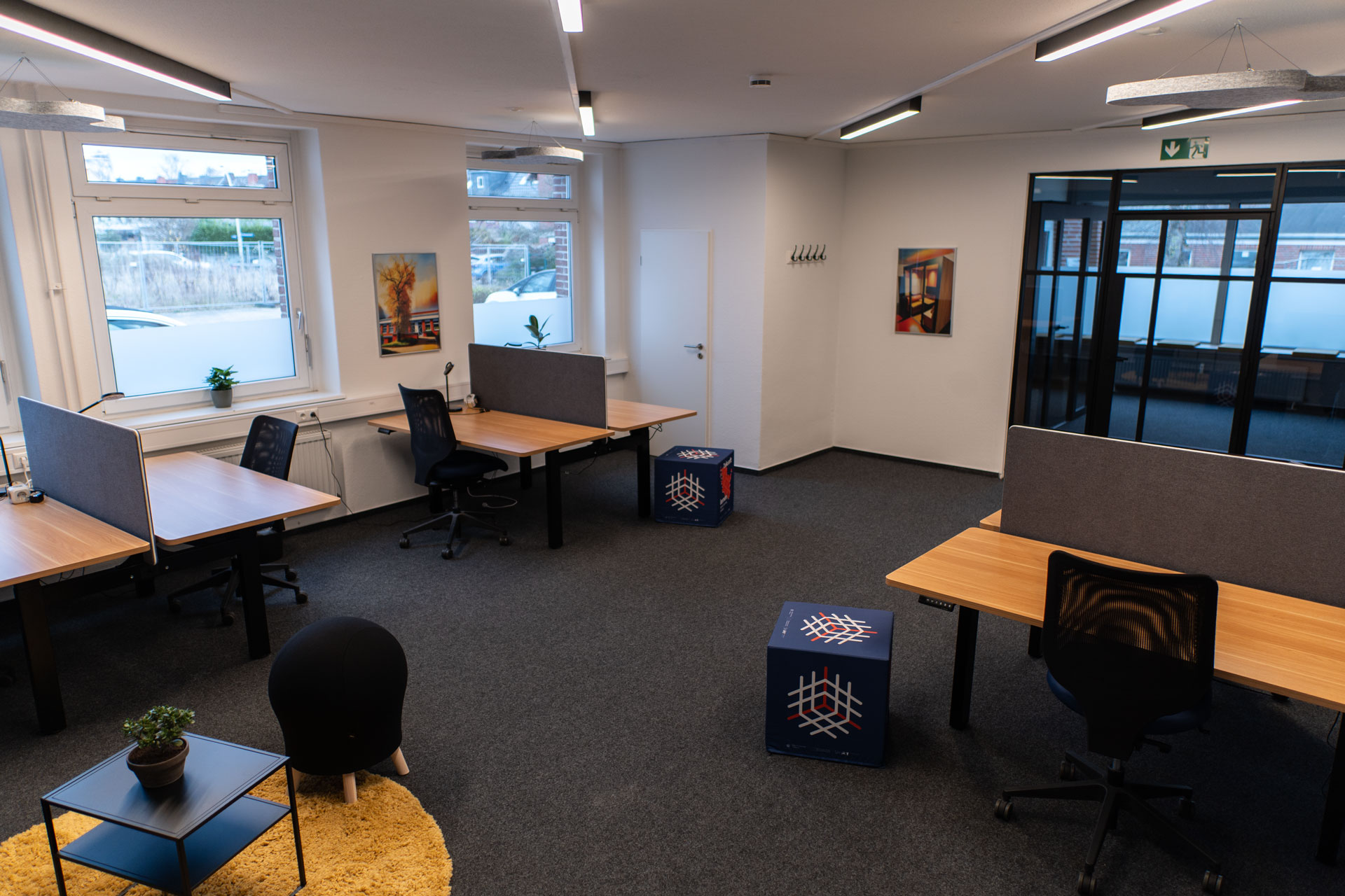 Büro mit höhenverstellbaren Schreibtischen und Sitzecke