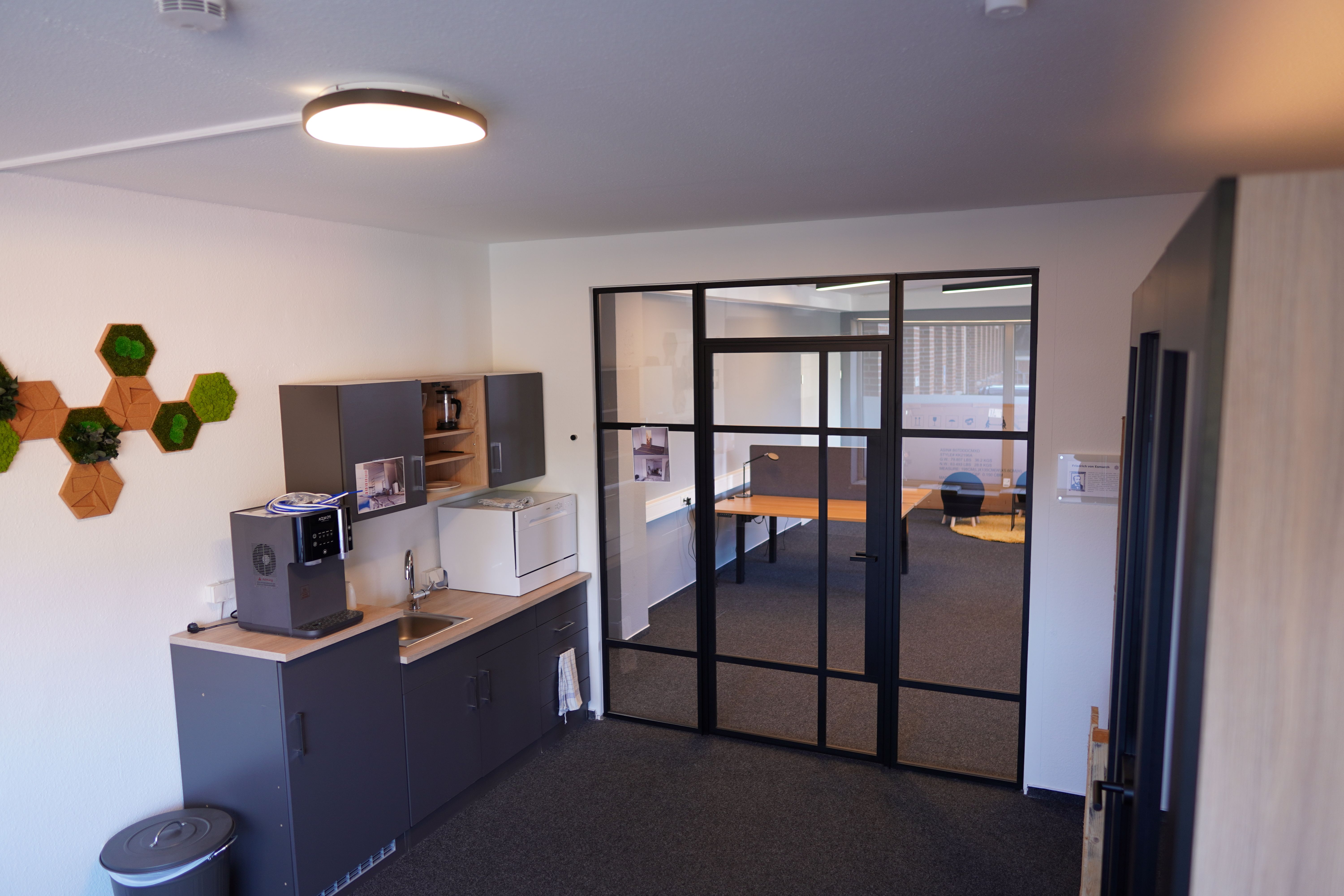 Kleine Küchenzeile neben einer großen Glastür